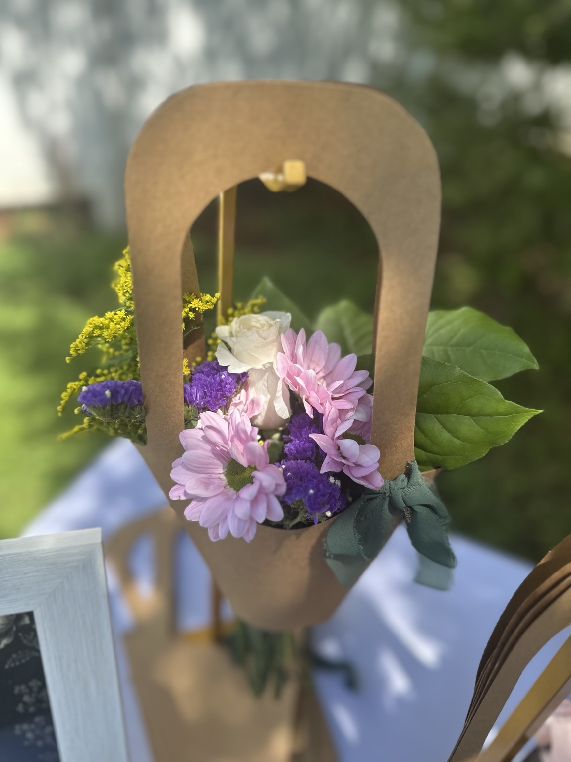 Finished floral bouquet displayed in a kraft bouquet holder